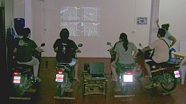 Four people playing GL-Tron indoors with real motorbikes