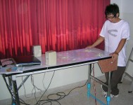 A student playing the virtual pinball table with the PVC leg extensions