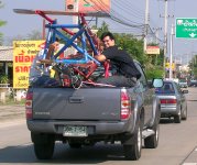 Transporting the cars with some students in the back of a truck.